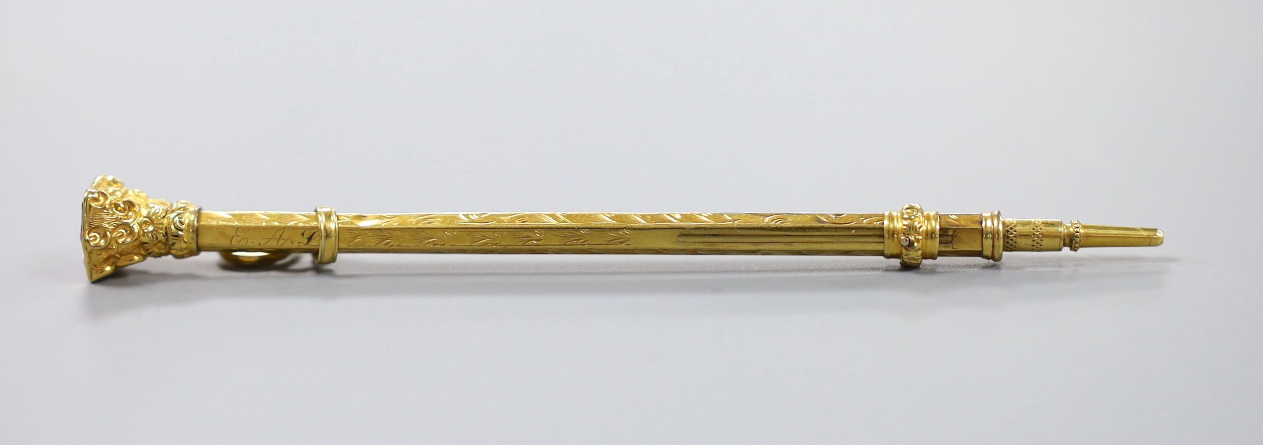 A Victorian chased yellow metal overlaid propelling pencil, with amethyst set terminal, 80mm.